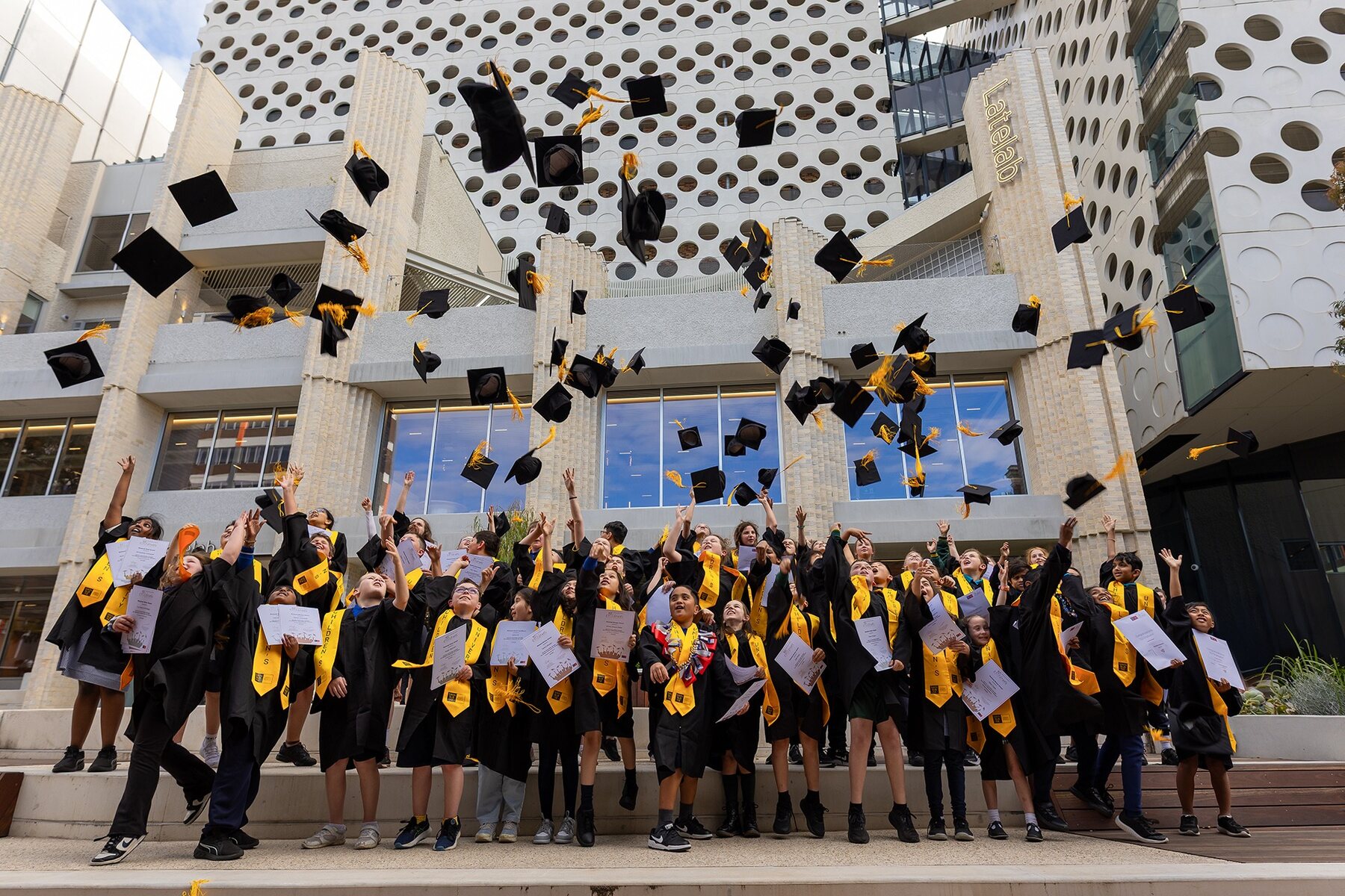Swinburne graduates celebrating outside the Melbourne campus