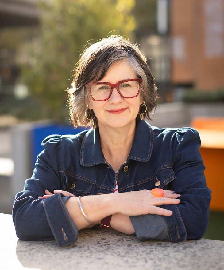 Environmental business portrait of a woman with red glasses outdoors