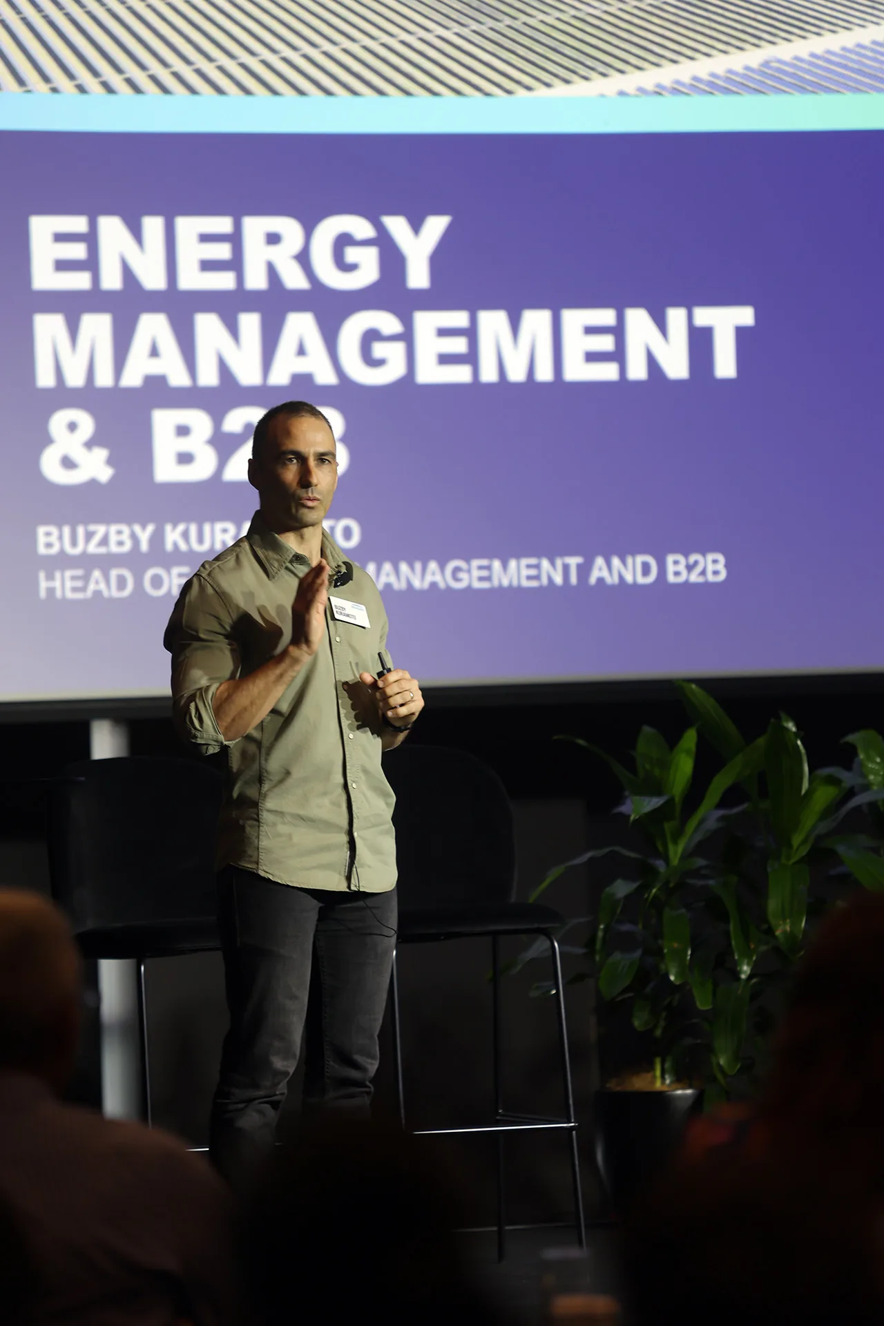 Speaker presenting against branded event signage in Melbourne