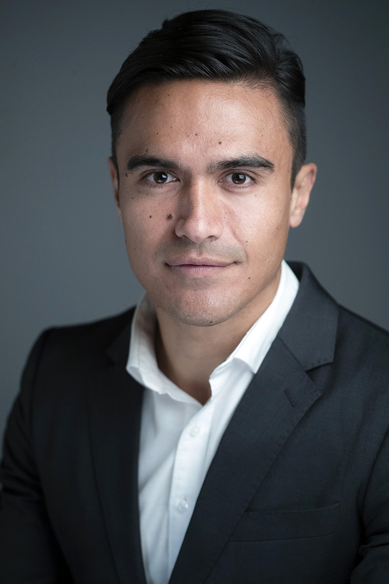 Executive headshot of a man in a dark suit against a grey background