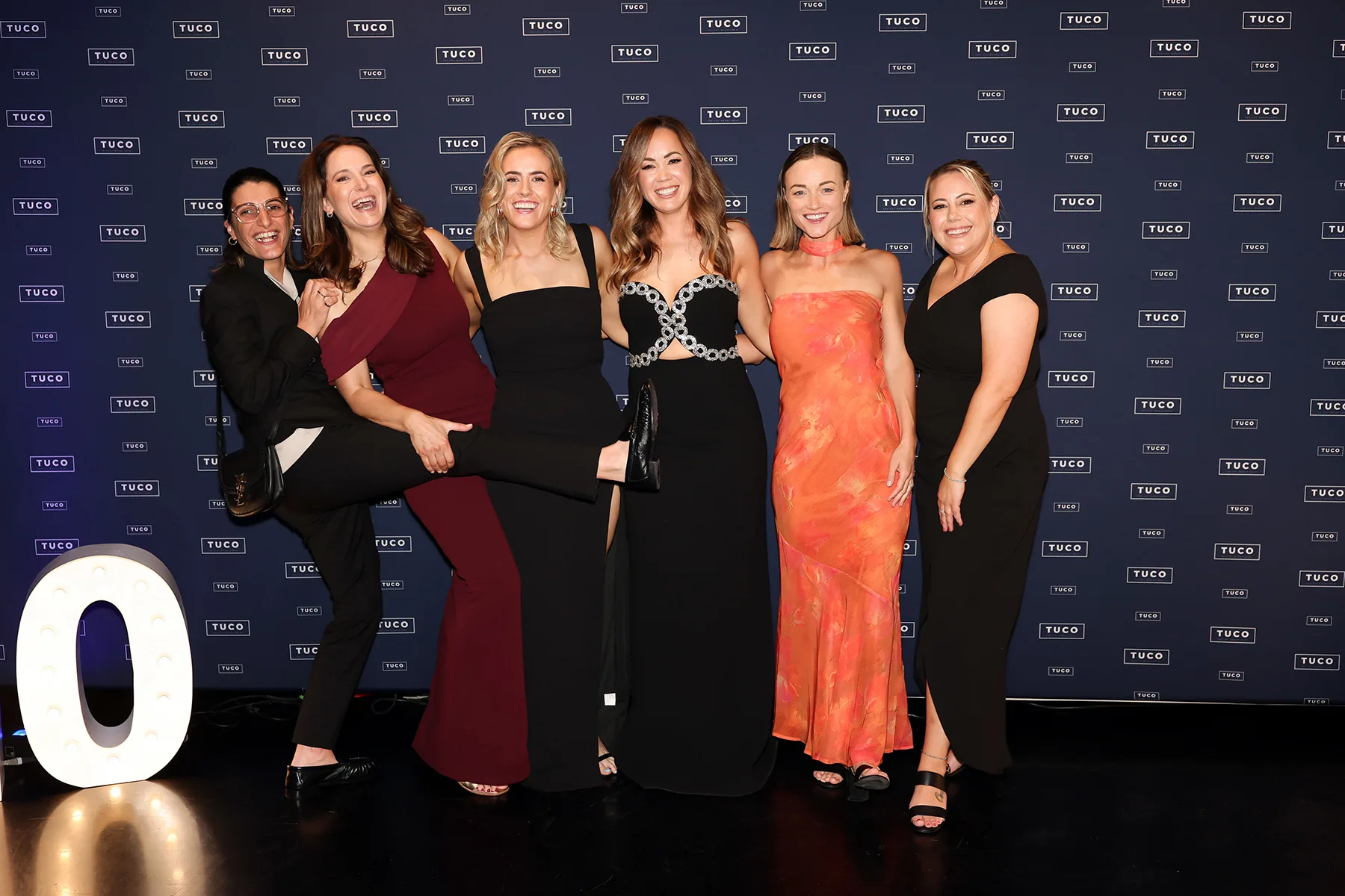 Guests photographed against a Tuco branded media wall at a Melbourne gala